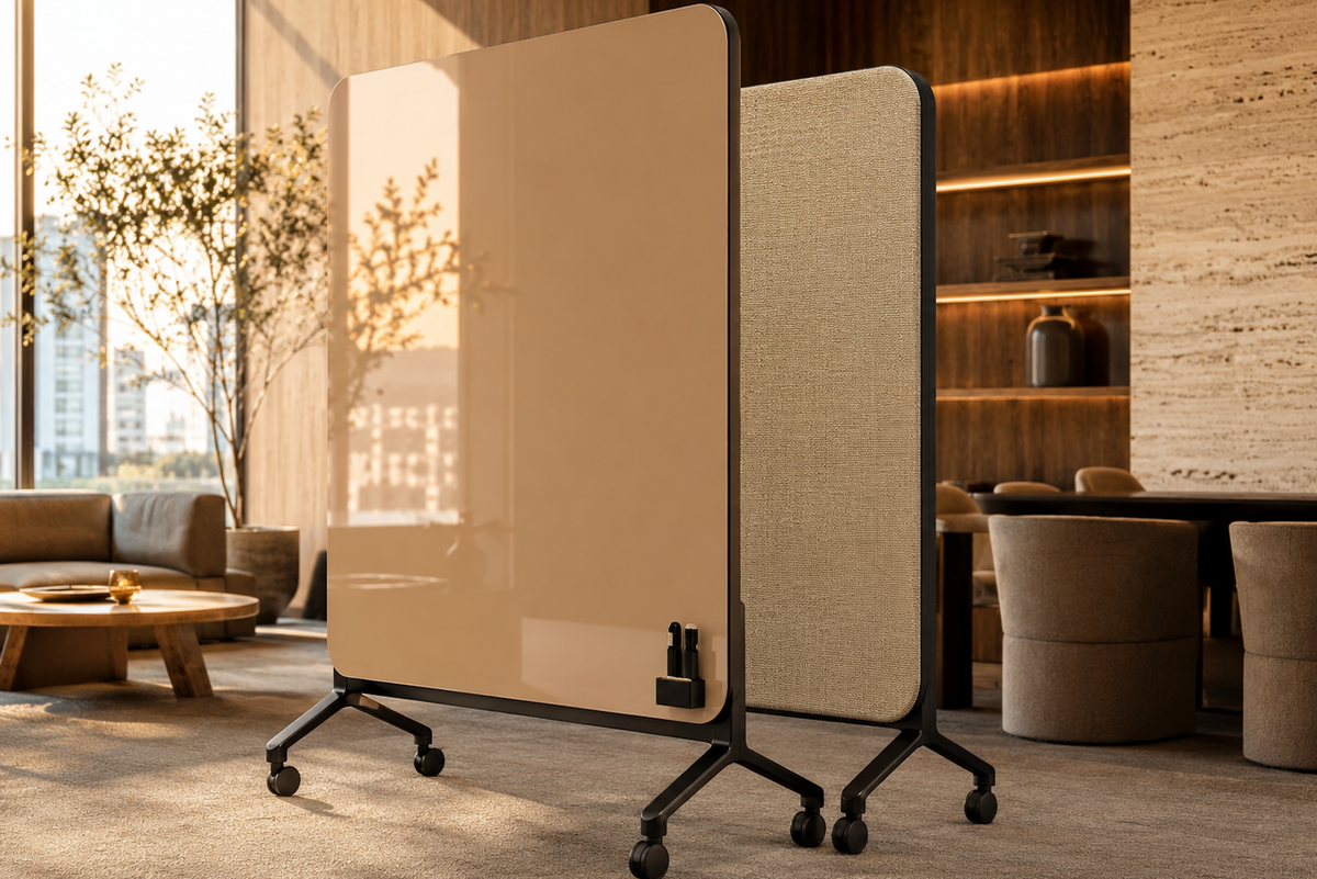 A modern rolling office partition screen with a glossy warm beige front panel and a textured beige fabric side panel, shown in a styled interior office setting.
